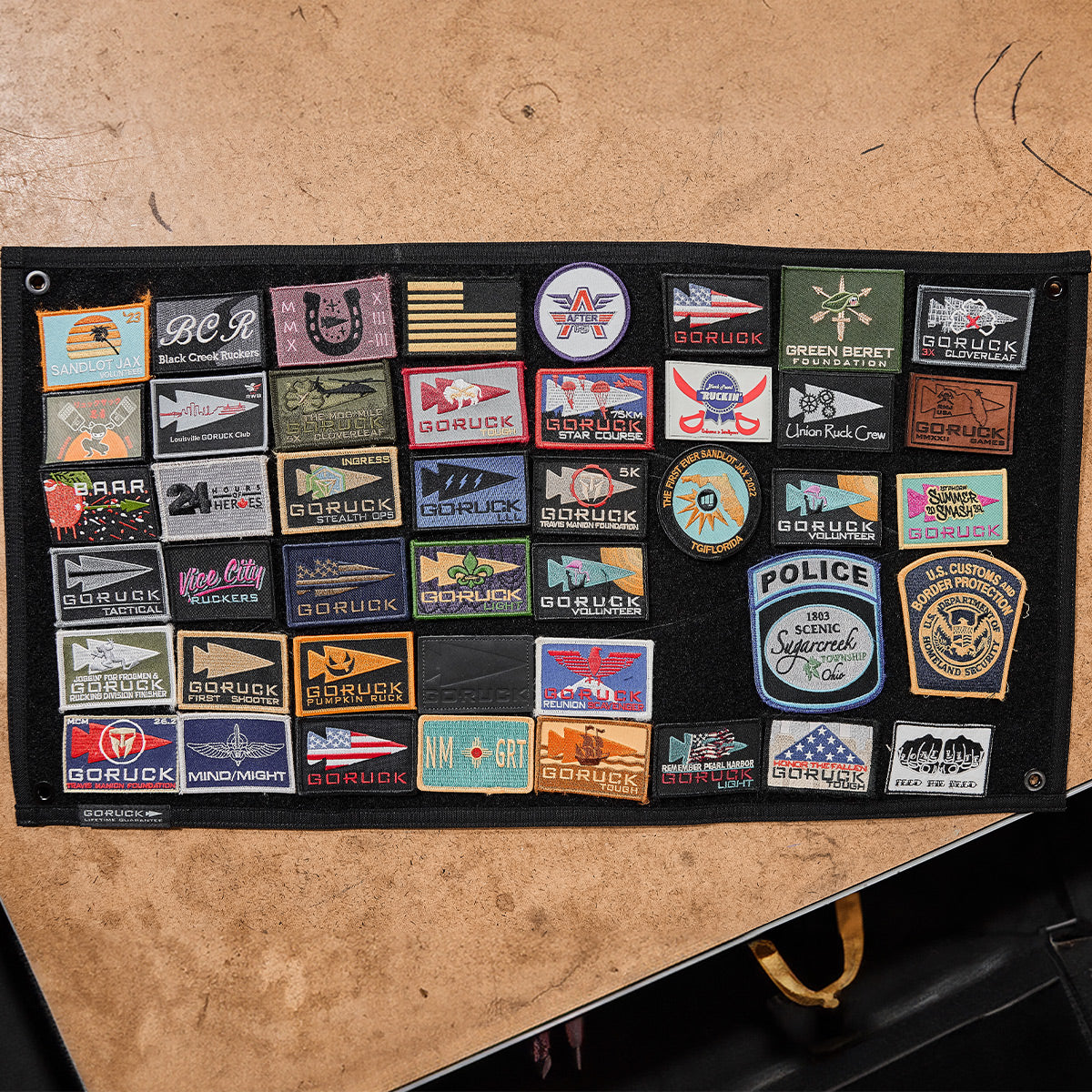 The GORUCK Spearhead Patch Board by GORUCK displays an array of vibrant embroidered patches featuring diverse designs and logos, all arranged neatly on a sturdy velcro panel.