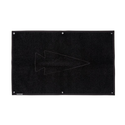 The black rectangular rug showcases a simple arrowhead design at its center, similar to the GORUCK Spearhead Patch Board, and is made with the robust 1000D Cordura material.