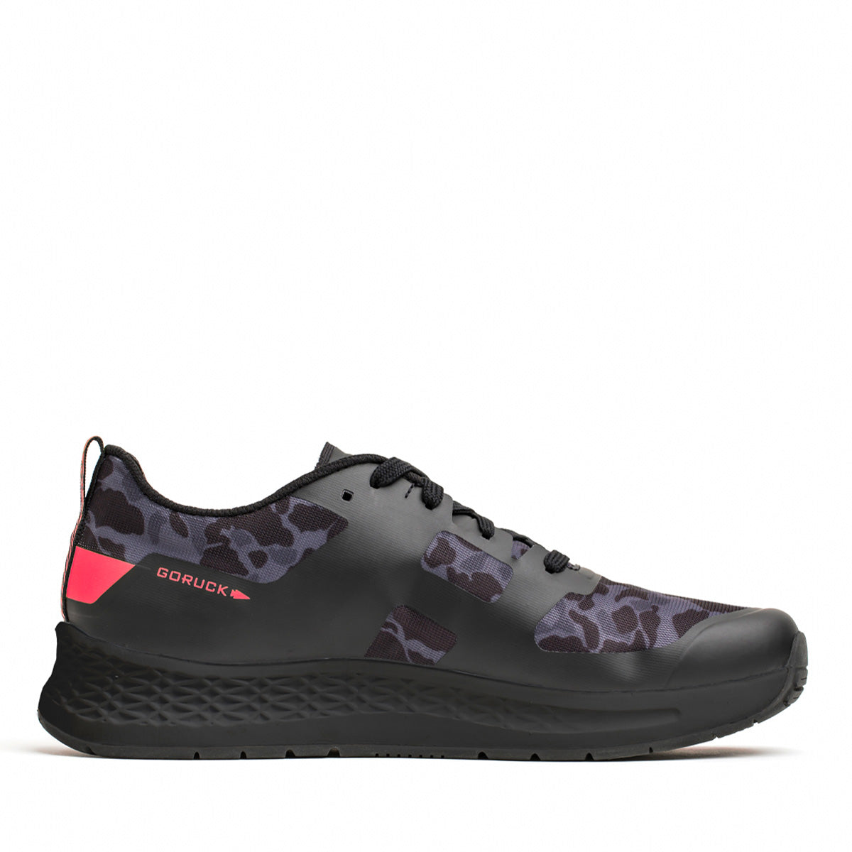 The Women's Rough Runner in Midnight Frogskin and High Risk Red, by GORUCK, is a stylish black sneaker featuring a camo-like print on its sides and red accents on the heel. It includes an EVA midsole for comfort, black laces, a textured black sole, and displays the GORUCK brand name in red on the heel.