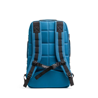 The Rucker 4.0, a blue rucksack with padded straps and a grid-patterned back, is shown upright and facing backward. Perfect for rucking adventures, it combines comfort and style.