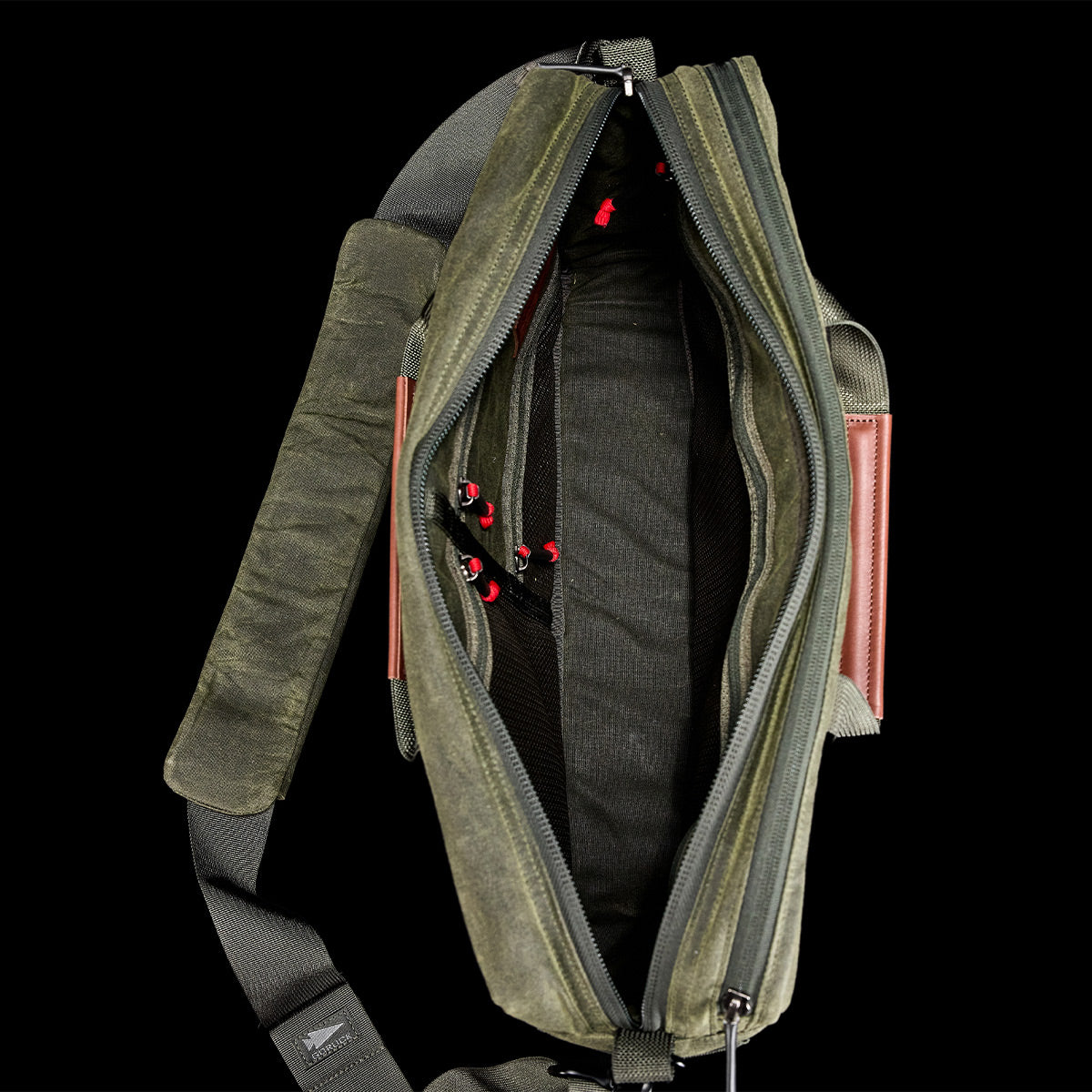 A top view of the GORUCK Shoulder Bag - Waxed Canvas, showcasing its multiple zippers and padded shoulder strap designed for comfortable, asymmetrical carries.