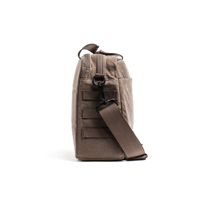 Side view of a taupe Shoulder Bag - Waxed Canvas by GORUCK, featuring asymmetrical carry, MOLLE webbing, and a Martexin Wax finish.