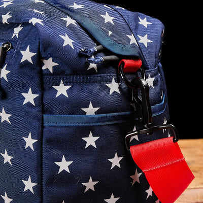 Product Name: Kit Bag (Includes Shoulder Strap) - blue aviator design featuring white stars, a red strap, and a black background.