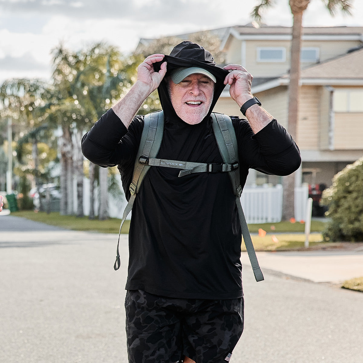 Man smiling while rucking in Men's Sun Hoodie - ToughMesh in Black