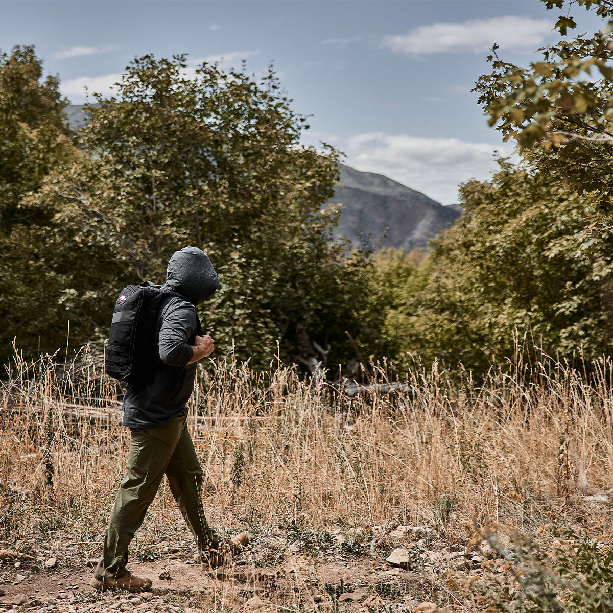 Man hiking wearing Men's Sun Hoodie - ToughMesh in Charcoal