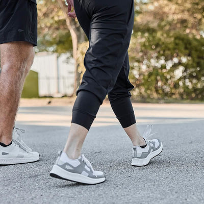 Detail shot of two people walking outdoors, Woman is wearing Women's Performance Joggers.