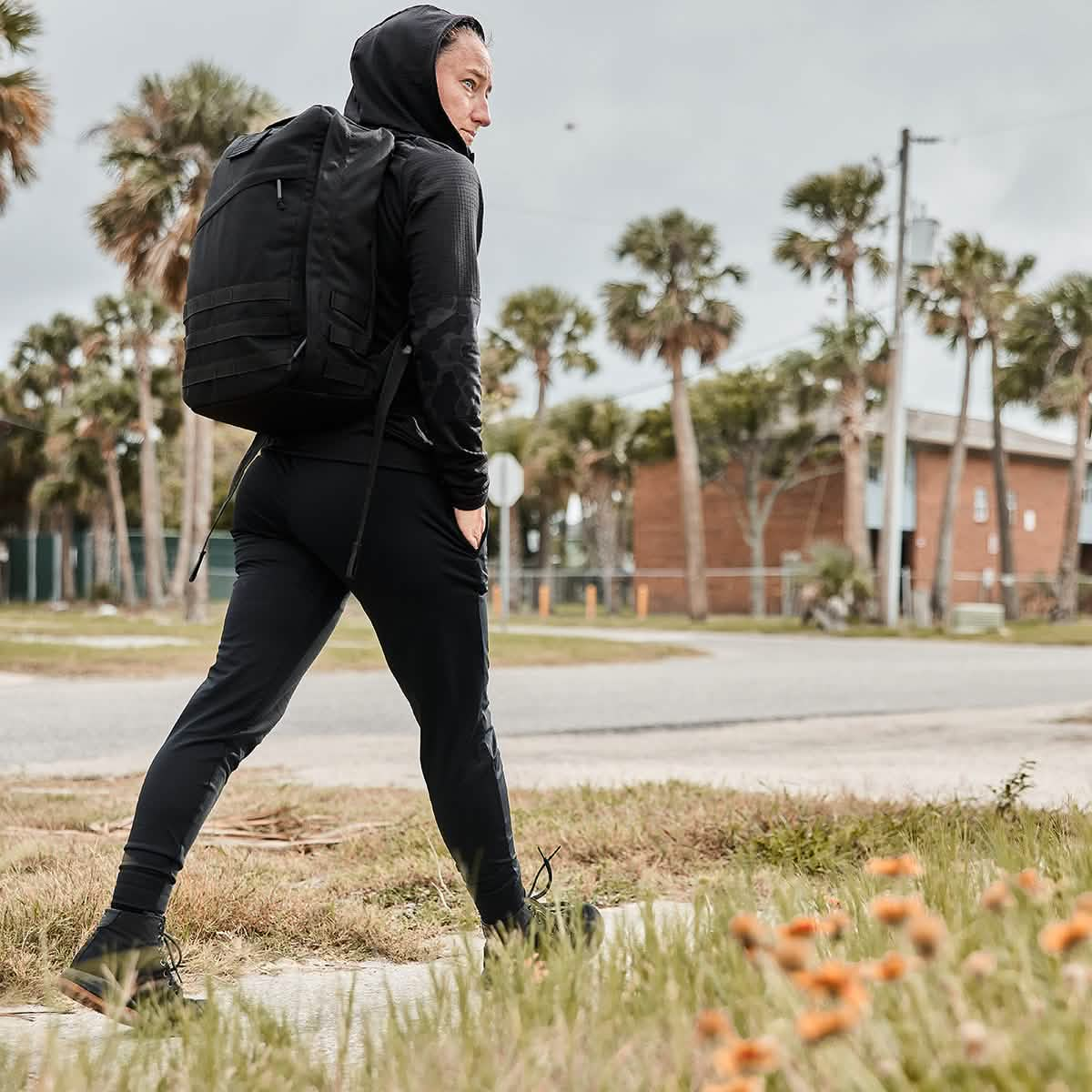 Woman walking outdoors, Woman is wearing Women's Performance Joggers and Rucksack.