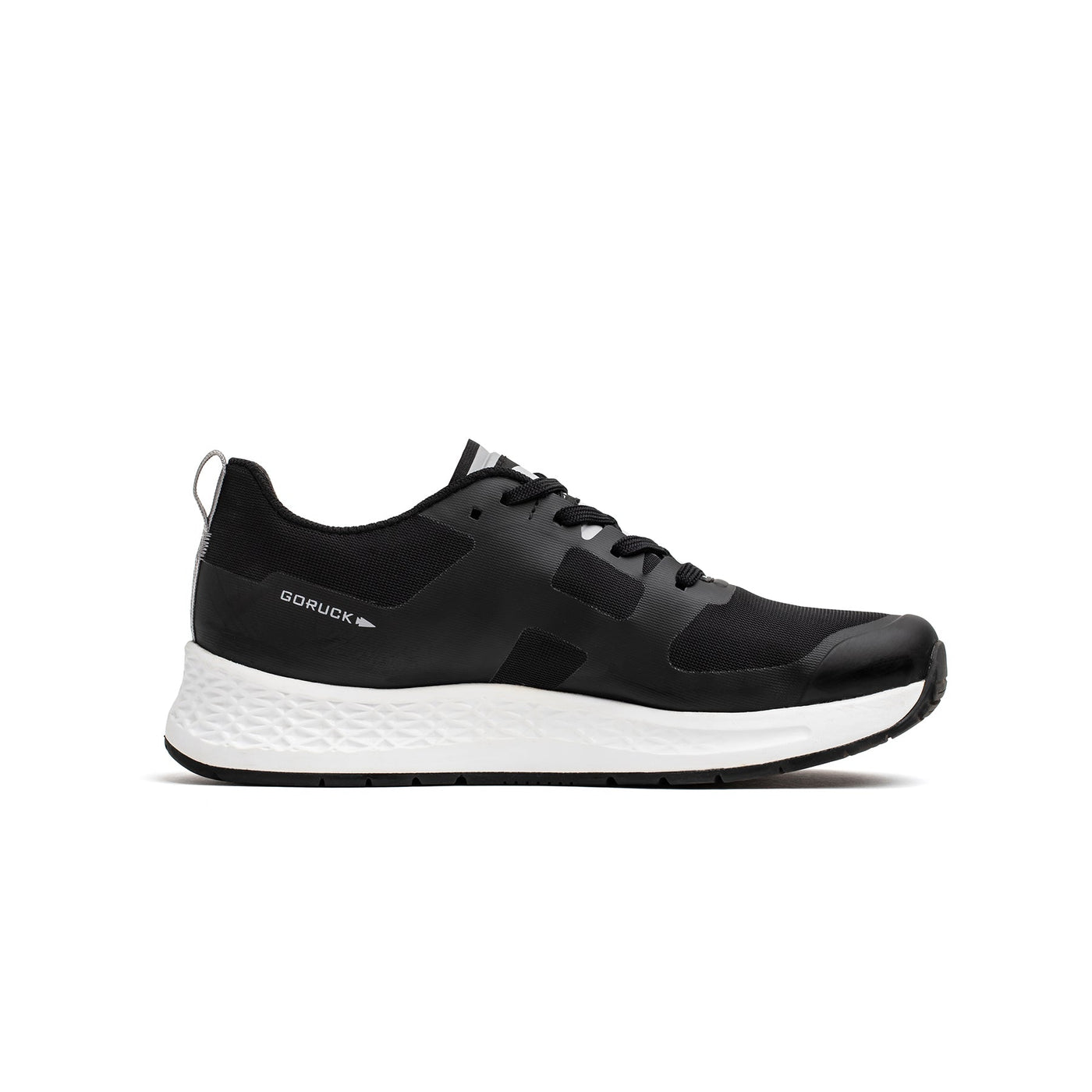 Introducing the Women's Rough Runner - Black + White by GORUCK: This sleek, modern athletic shoe features a black design with a white textured sole. The lace-up style is enhanced by Gradient Density™ technology, offering both performance and comfort. Subtle branding on the side completes its sophisticated look.