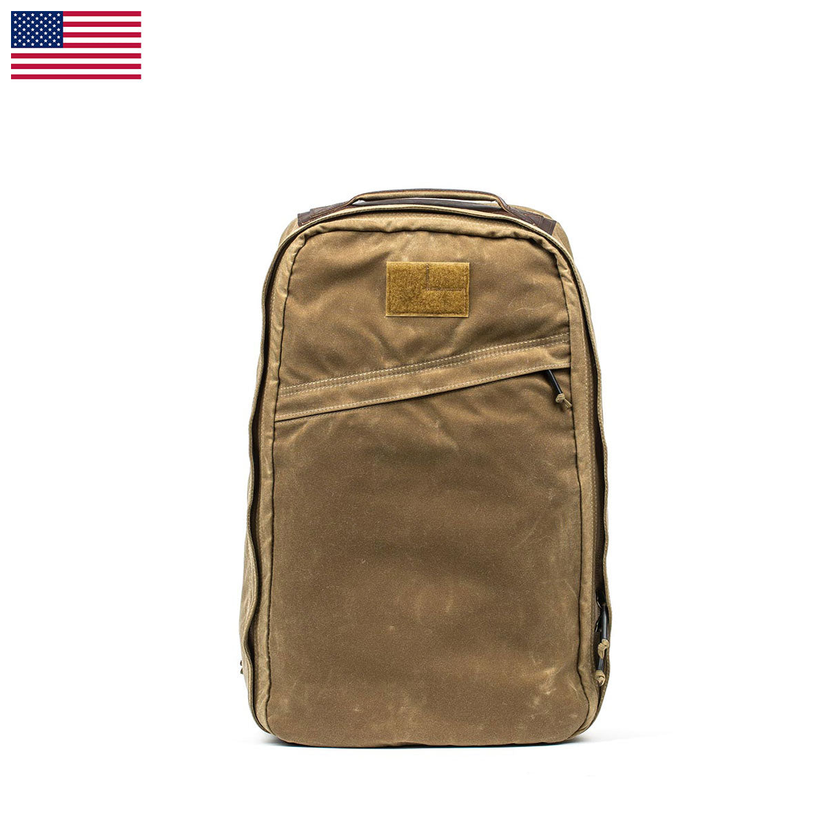 The GR1 USA - Heritage rucksack by GORUCK is featured in a rich brown hue against a white background. It features a rectangular patch on the front pocket, made from durable waxed duck canvas. An American flag is positioned in the upper left corner of the image, enhancing this timeless design with a patriotic touch.