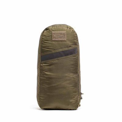 The Packable Bullet Ruck in olive green, crafted from durable Ripstop ROBIC® nylon, features AquaGuard zippers for extra protection. Its sleek design includes a side zipper and top patch, perfect for modern adventurers.