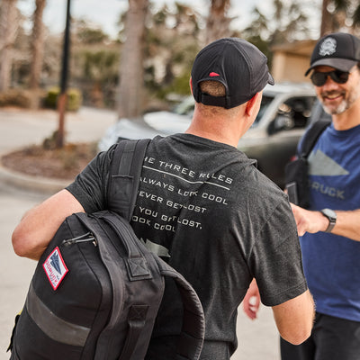 Two men outdoors in photos—one holds a black bag and wears the Three Rules Tee - Tri-Blend, featuring the phrase, "Always look cool. Never get lost.