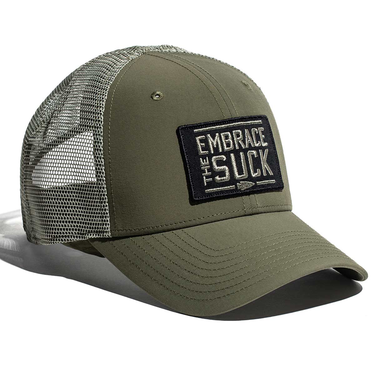 The Performance Trucker Hat - Embrace the Suck by GORUCK comes in olive green and includes a mesh back with a front patch featuring the slogan "EMBRACE THE SUCK." Made from sweat-wicking material for enhanced comfort, it is equipped with an adjustable Velcro strap to ensure the perfect fit.